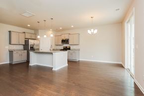 Moncks Corner house for rent - A spacious kitchen with wooden floors and white cabinetry.