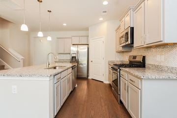 Moncks Corner house for rent - A kitchen with white cabinets and a stainless steel refrigerator.