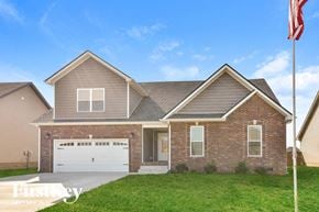 Clarksville house for rent - a brick house with a white garage door and a flag on a lawn