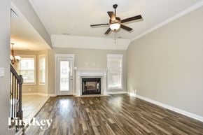 Clarksville house for rent - a living room with a fireplace and a ceiling fan