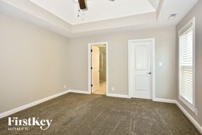 Clarksville house for rent - a bedroom with a carpeted floor and a white door