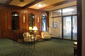 Victoria apartment for rent - A room with a green carpet and a wooden wall.