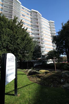 Victoria apartment for rent - a tall building in the background with a sign in the grass