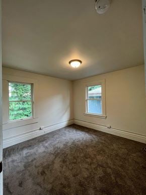Donora house for rent - A room with a carpeted floor and two windows.