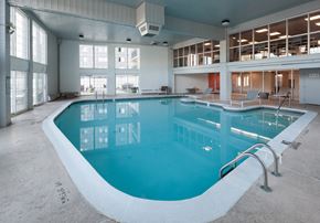 Westland apartment for rent - a swimming pool in a building with large windows and a blue pool