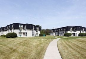 Westland Mi apartment for rent - a sidewalk leading to a row of houses on a grass field
