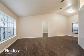 Saint Cloud house for rent - A spacious room with wooden flooring and a large window with blinds.