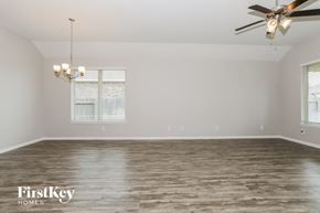Conroe house for rent - the spacious living room with wood flooring and a ceiling fan