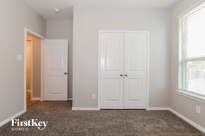 Conroe house for rent - a bedroom with two closet doors and a carpeted floor