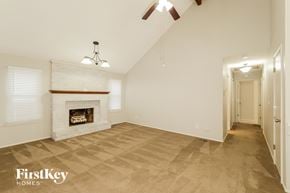 Lenexa house for rent - a living room with a fireplace and a ceiling fan