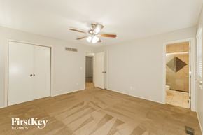 Lenexa house for rent - a bedroom with a ceiling fan and a door to a bathroom