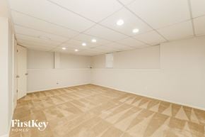 Lenexa house for rent - a spacious room with white walls and tile flooring