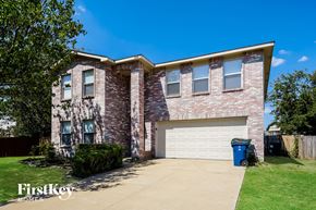 Mckinney house for rent - A brick house with a garage and a blue trash bin.