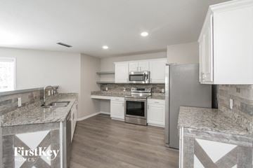 Charlotte house for rent - a kitchen with marble counter tops and white cabinets