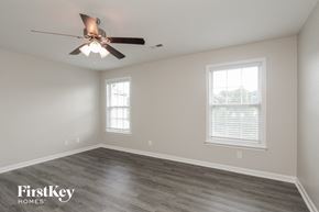 Charlotte house for rent - a bedroom with a ceiling fan and two windows