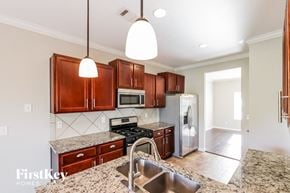 Bessemer house for rent - a kitchen with wooden cabinets and stainless steel appliances and granite counter tops