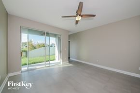 Bradenton house for rent - A spacious room with a ceiling fan and sliding glass doors leading to a backyard.
