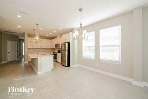 Bradenton house for rent - A spacious kitchen with a refrigerator, sink, and cabinets.