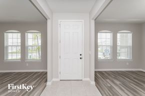 Parrish house for rent - A room with a white door and windows with blinds.