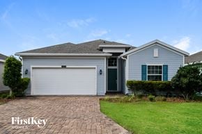 Jacksonville house for rent - a blue house with a garage door and a green lawn