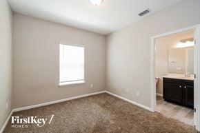 Jacksonville house for rent - a bedroom with a carpeted floor and a bathroom with a sink