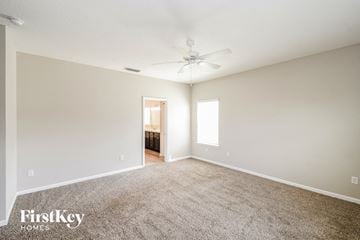 Jacksonville house for rent - a spacious living room with carpet and a ceiling fan