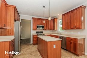 Springboro house for rent - a kitchen with wooden cabinets and stainless steel appliances and white counter tops