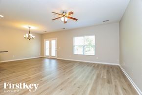 White House house for rent - A spacious room with a ceiling fan and wooden flooring.