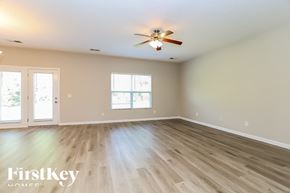White House house for rent - A spacious room with a ceiling fan and wooden flooring.