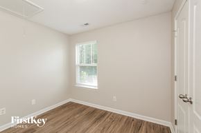 Mooresville house for rent - a bedroom with white walls and wood flooring and a window