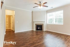 Chelsea house for rent - A spacious living room with a fireplace and a ceiling fan.