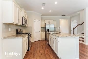Chelsea house for rent - A kitchen with white cabinets and a FirstKey Homes logo.
