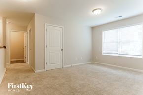 Chelsea house for rent - A spacious room with a carpeted floor and a window with blinds.
