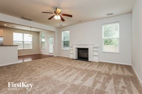 Moncks Corner house for rent - A spacious living room with a fireplace and a ceiling fan.