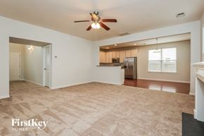 Moncks Corner house for rent - A spacious living room with a carpeted floor and a ceiling fan.