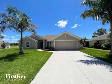 Punta Gorda house for rent - a house with a driveway and palm trees