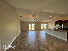 Punta Gorda house for rent - an empty living room and kitchen with a ceiling fan