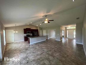 Punta Gorda house for rent - an empty living room and kitchen with a ceiling fan