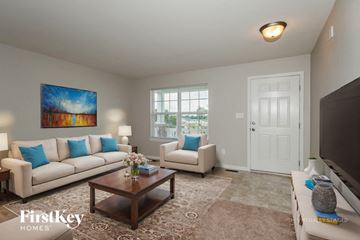 Wentzville house for rent - A living room with a couch, a coffee table, and a painting on the wall.