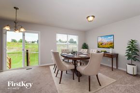 Wentzville house for rent - A dining room with a table set for four and a painting of a mountain scene on the wall.