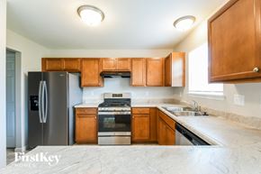 Wentzville house for rent - A kitchen with wooden cabinets and a stainless steel refrigerator.