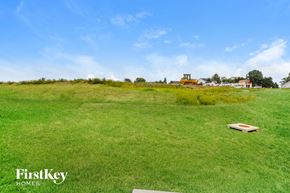 Wentzville house for rent - A large grassy field with a FirstKey Homes logo in the corner.