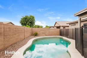 Peoria house for rent - A small pool with a hot tub in the middle of a backyard.