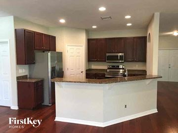 Lehigh Acres house for rent - A kitchen with brown cabinets and a white island.
