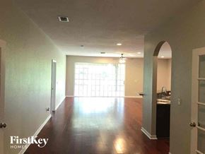 Lehigh Acres house for rent - A spacious room with wooden floors and a large window.