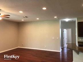 Lehigh Acres house for rent - A room with wooden floors and a ceiling fan.