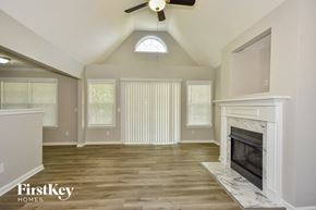 Mount Juliet house for rent - A spacious living room with a fireplace and a ceiling fan.