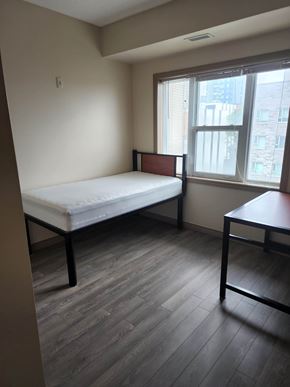 Waterloo apartment for rent - A bedroom with a bed, a table and a window.