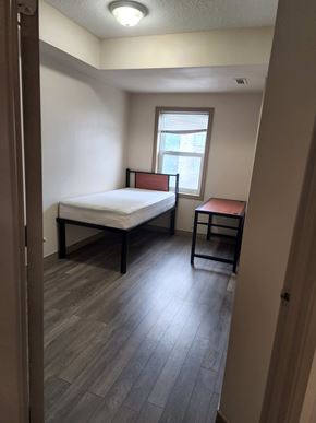 Waterloo apartment for rent - A bedroom with a bed, chair, and window.