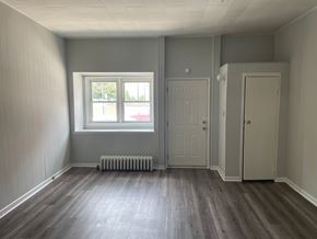 Gloucester City apartment for rent - A room with a window, two doors, and a radiator.